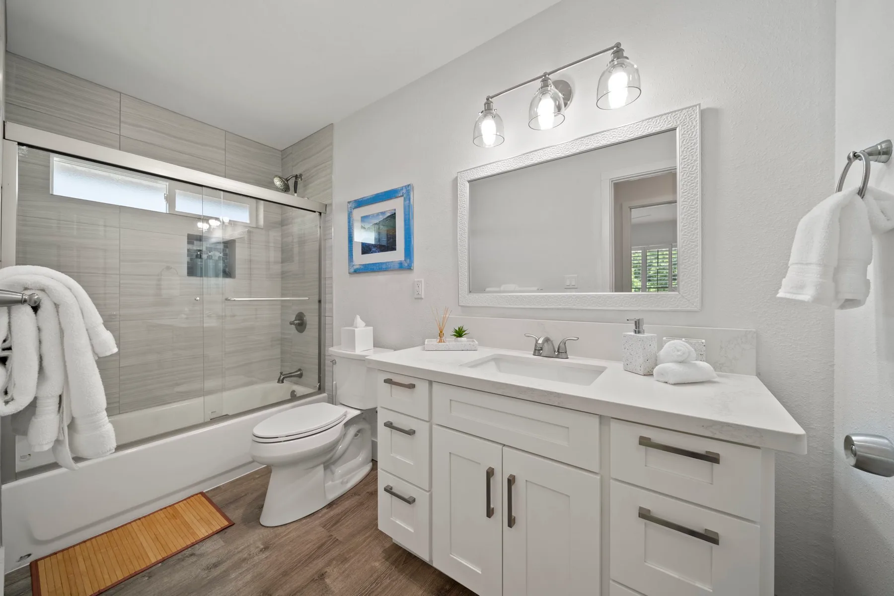 Un baño luminoso con bañera, mampara de ducha y tocador.