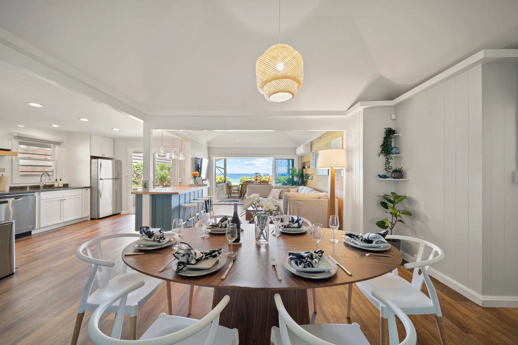 Un comedor abierto con la mesa puesta junto a una cocina luminosa.