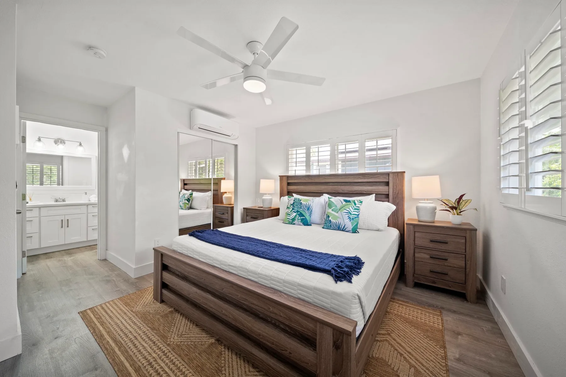 Un dormitorio luminoso con una cama de madera y un ventilador de techo.