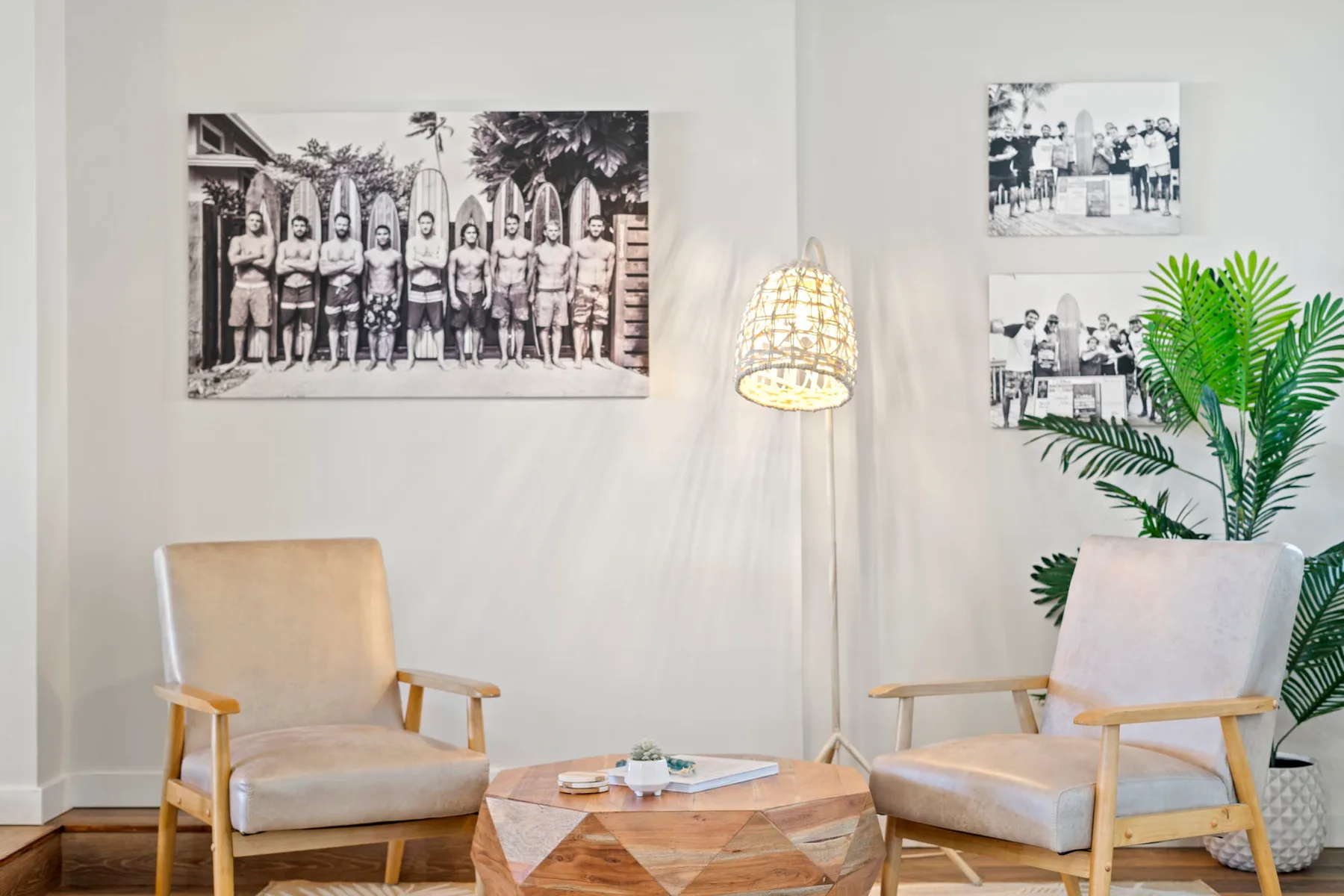 Una sala luminosa con dos sillones, una mesa de centro y fotografías enmarcadas.