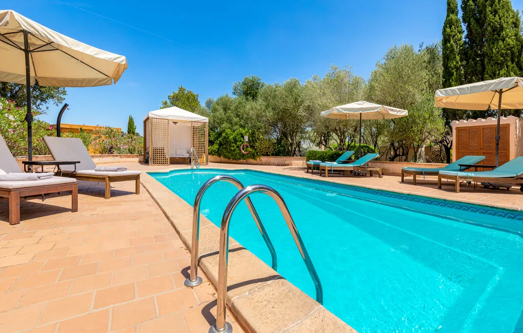 Una piscina al aire libre está rodeada de asientos y sombrillas.