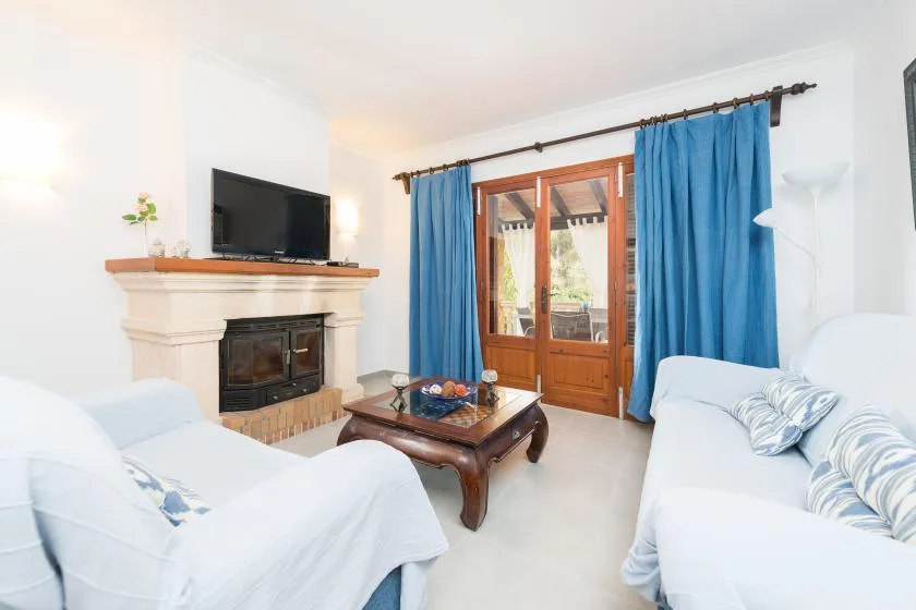 Una luminosa sala de estar con asientos, una mesa de centro y una chimenea.