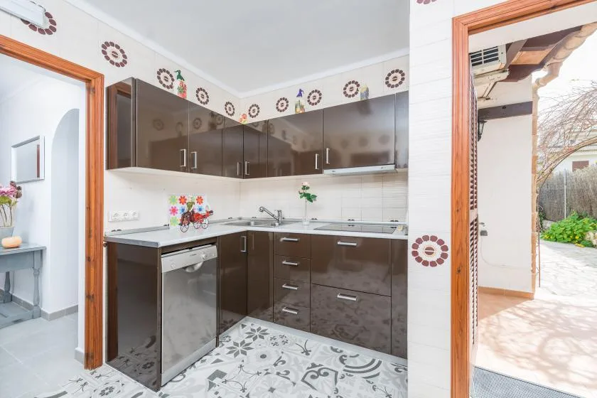Una cocina con gabinetes oscuros, un salpicadero de azulejos y una encimera.
