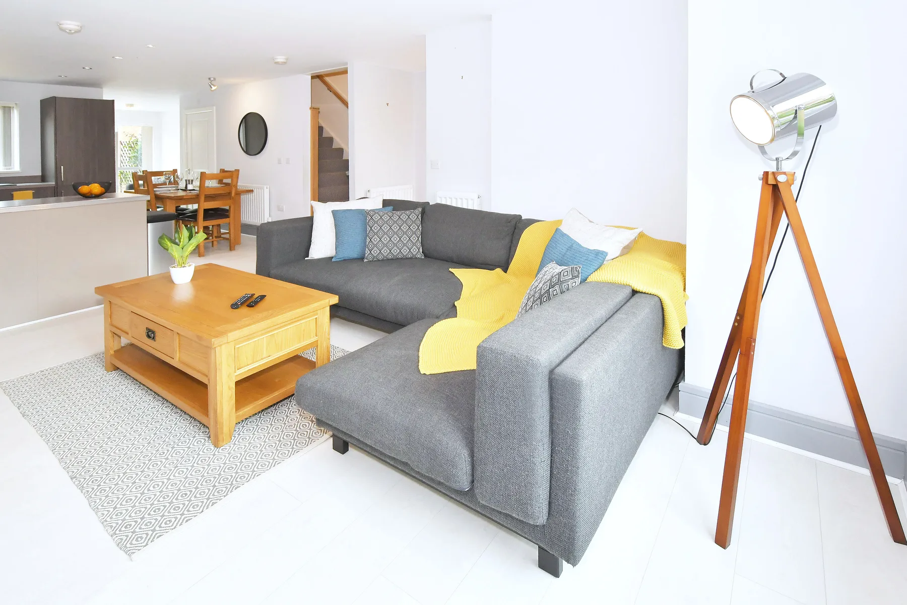 A bright living room with gray seating and a wooden coffee table.