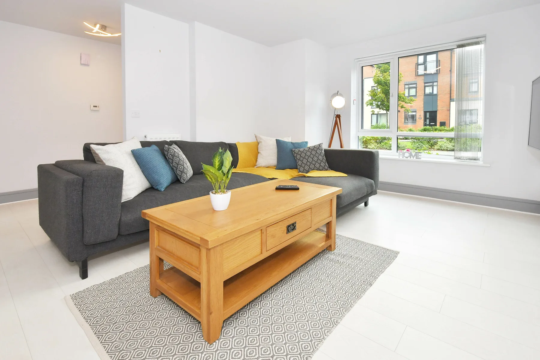 A living room with a sectional sofa and a wooden coffee table.