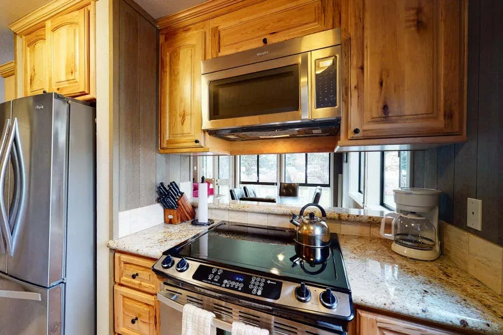 Una cocina con gabinetes de madera, una estufa y una encimera.