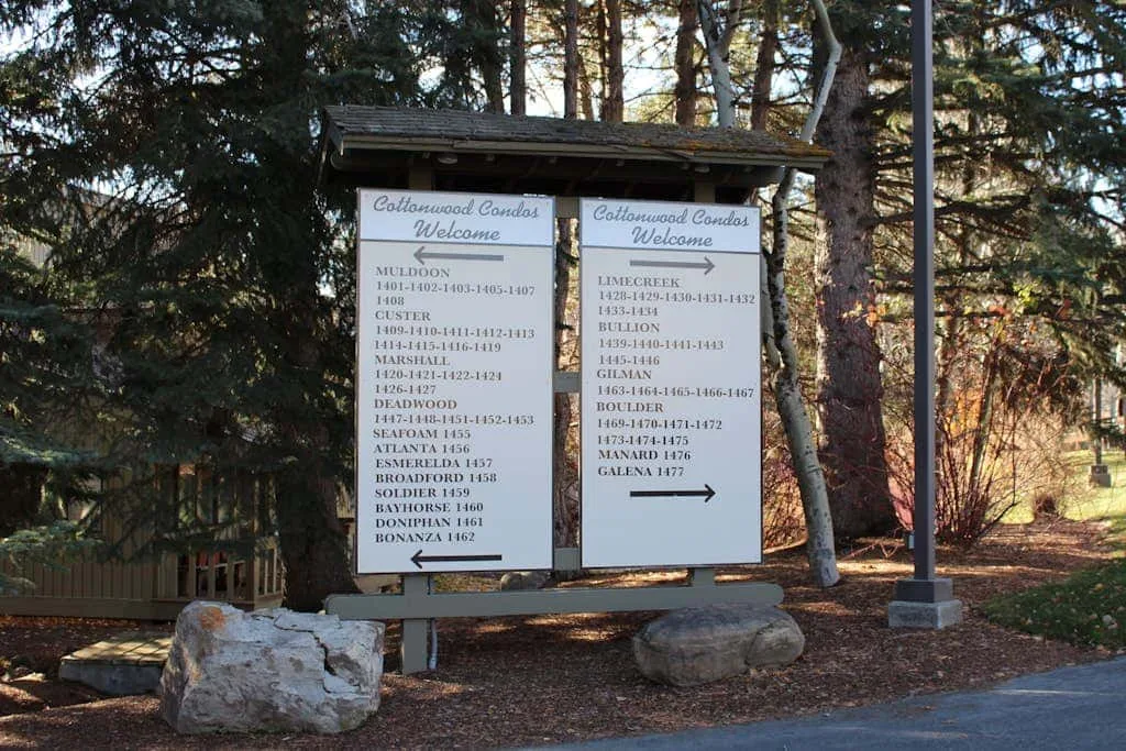 Un par de letreros informativos está junto a un sendero arbolado.