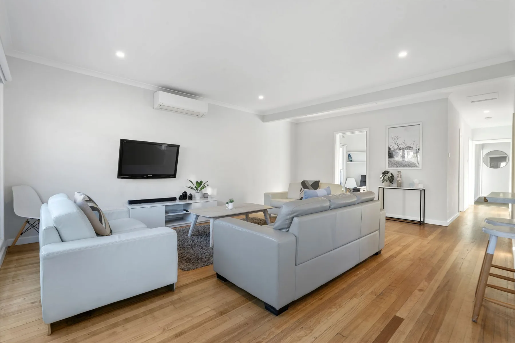 A bright living room with seating arranged around a television.