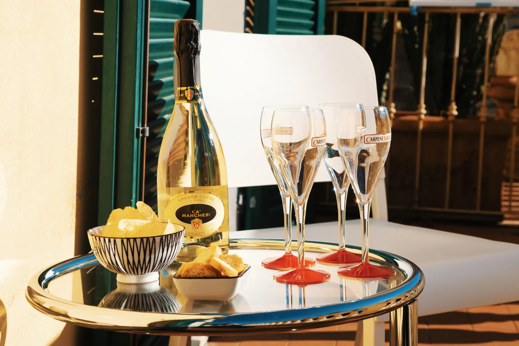 A small table holds a bottle of sparkling wine, glasses, and a bowl of snacks.