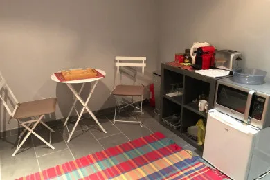A small kitchenette with a microwave, sink, and table and chairs.