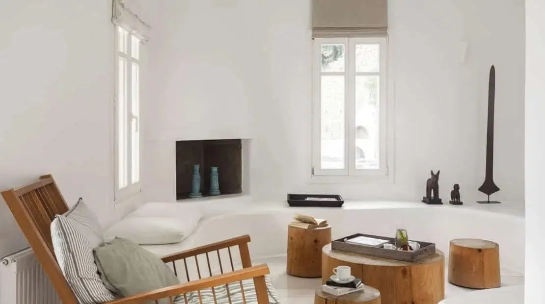 Una luminosa sala de estar con un banco empotrado y asientos de madera.