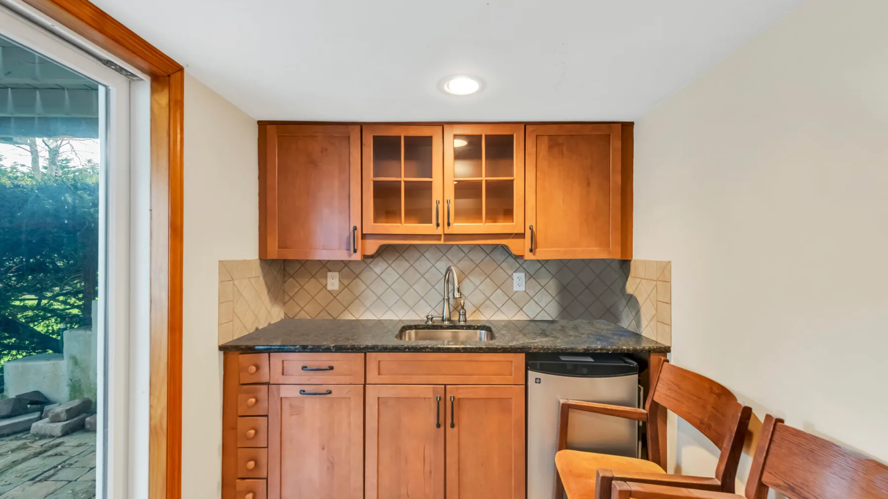 Una cocina con gabinetes de madera y una encimera junto a una ventana.