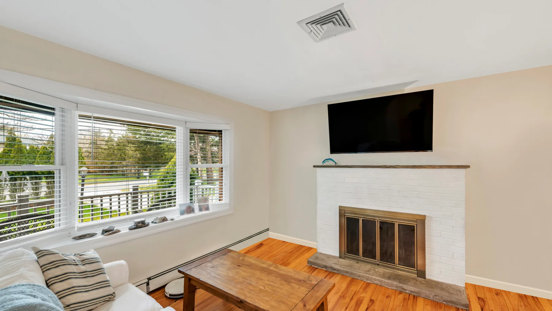 Una sala de estar con chimenea, televisor y mesa de centro de madera.