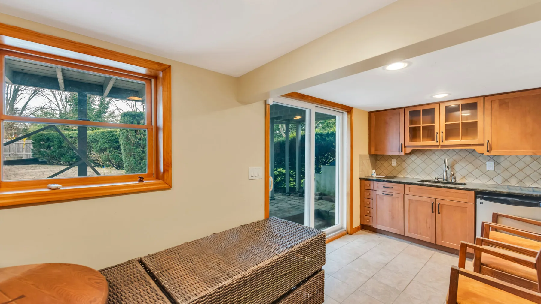 Una cocina y comedor con gabinetes de madera y puertas corredizas de vidrio.