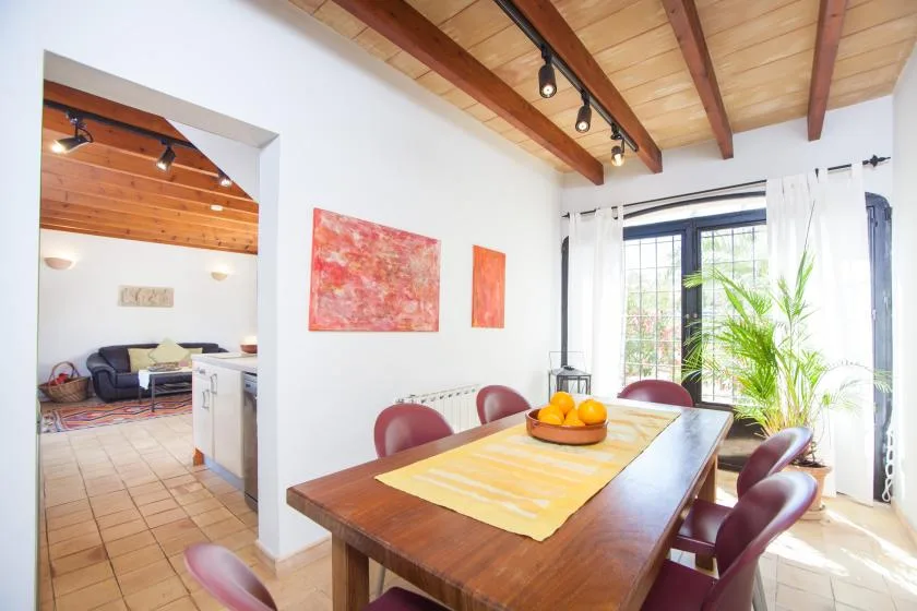 Un comedor con una mesa de madera, sillas y una ventana luminosa.
