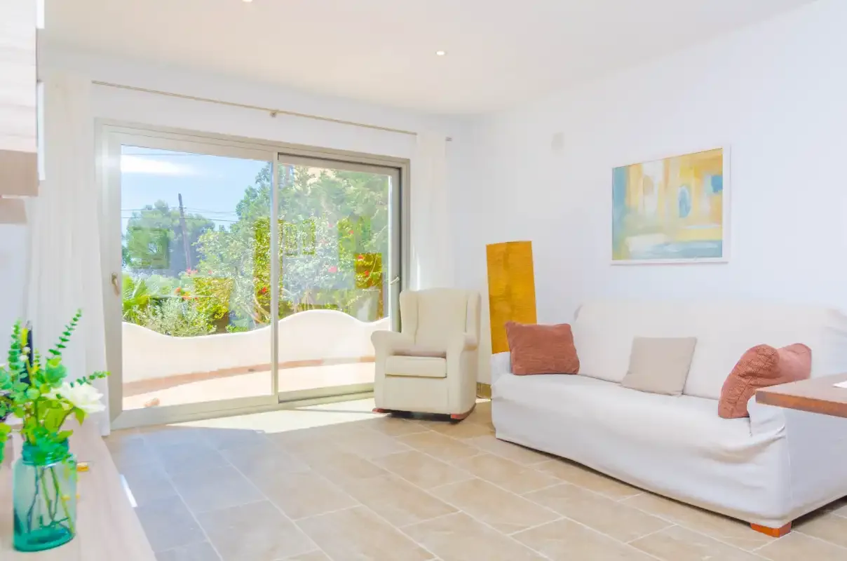 A bright living room with seating beside large sliding glass doors.