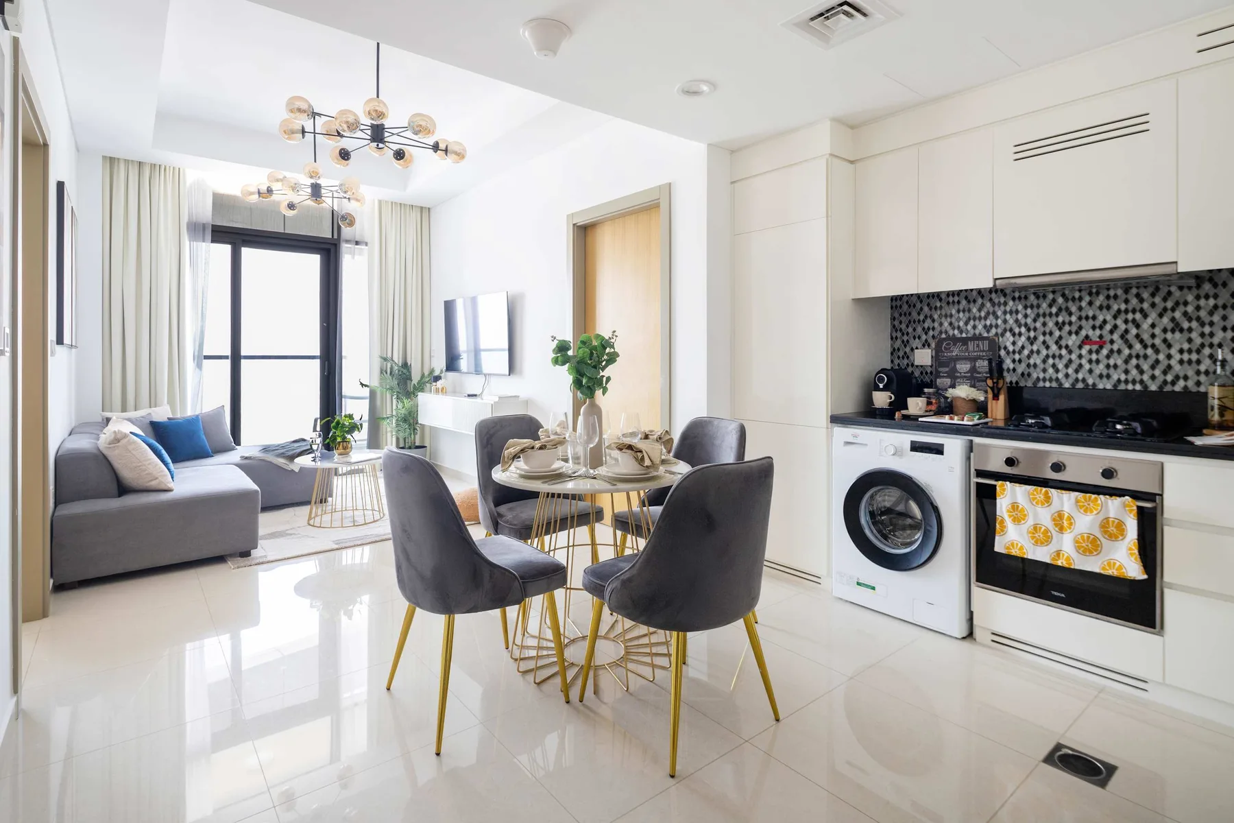 Una luminosa sala de estar diáfana con mesa de comedor y una cocina compacta.