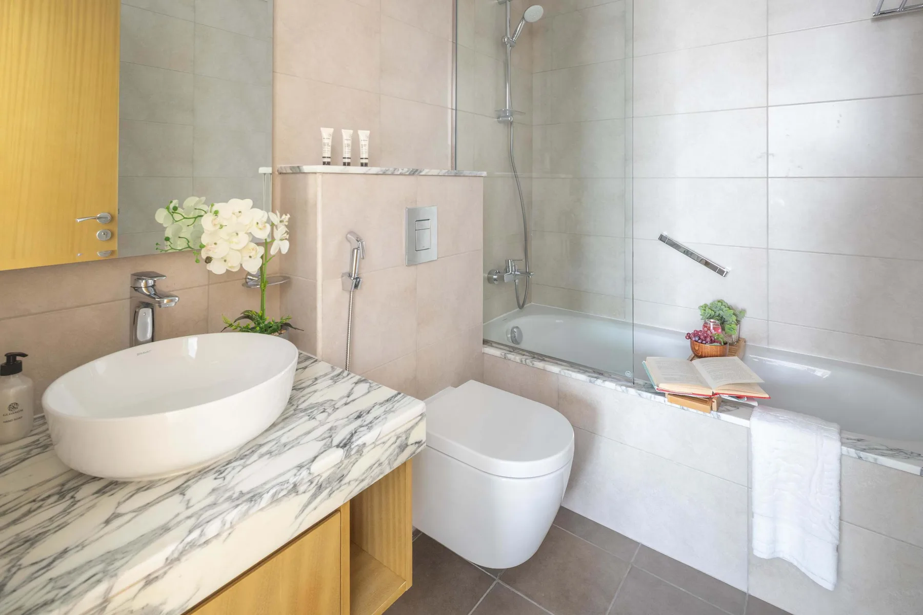 A tiled bathroom with a bathtub, toilet, and sink.