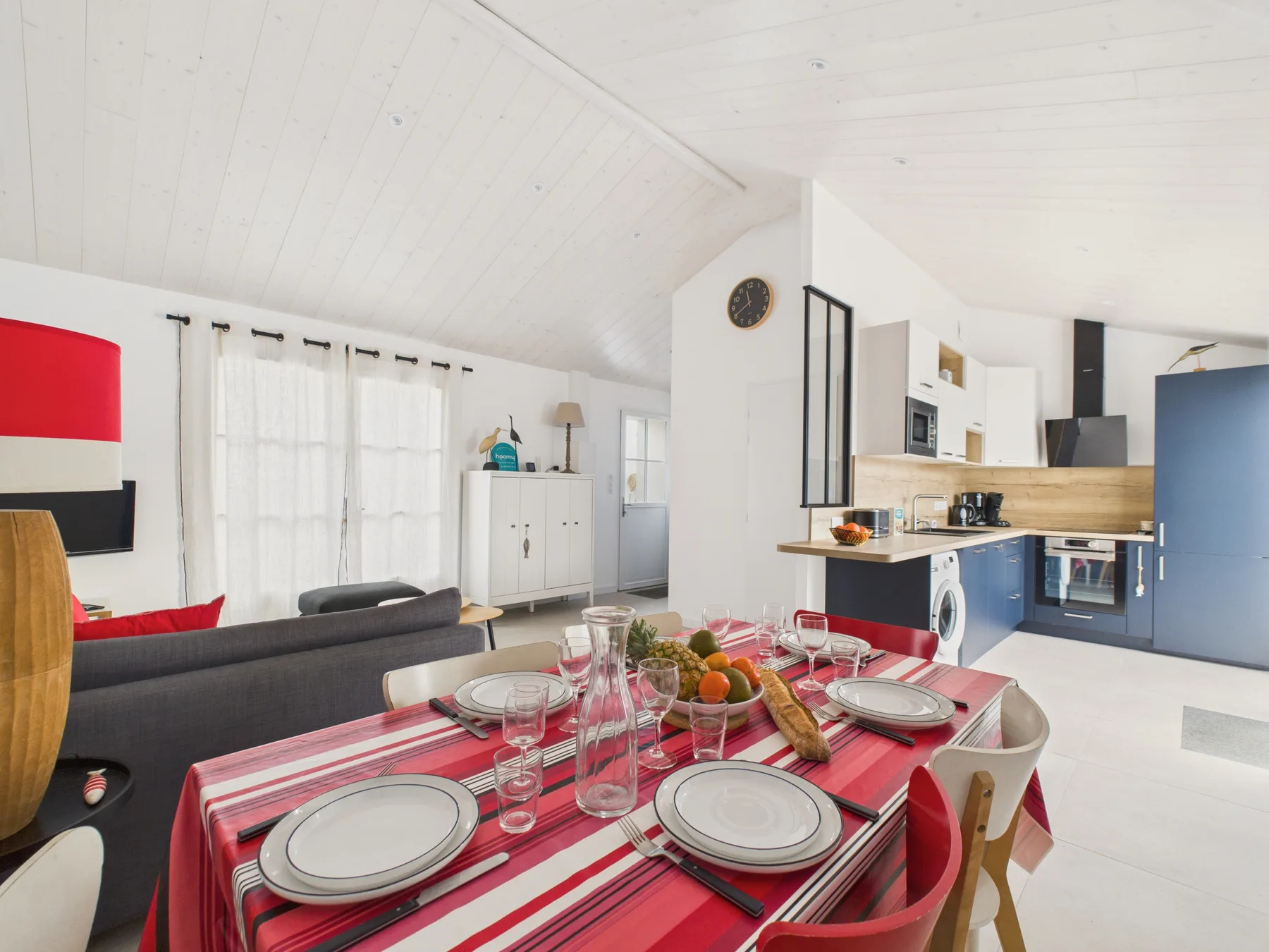 Open-plan living and dining area with a kitchen and a set dining table.