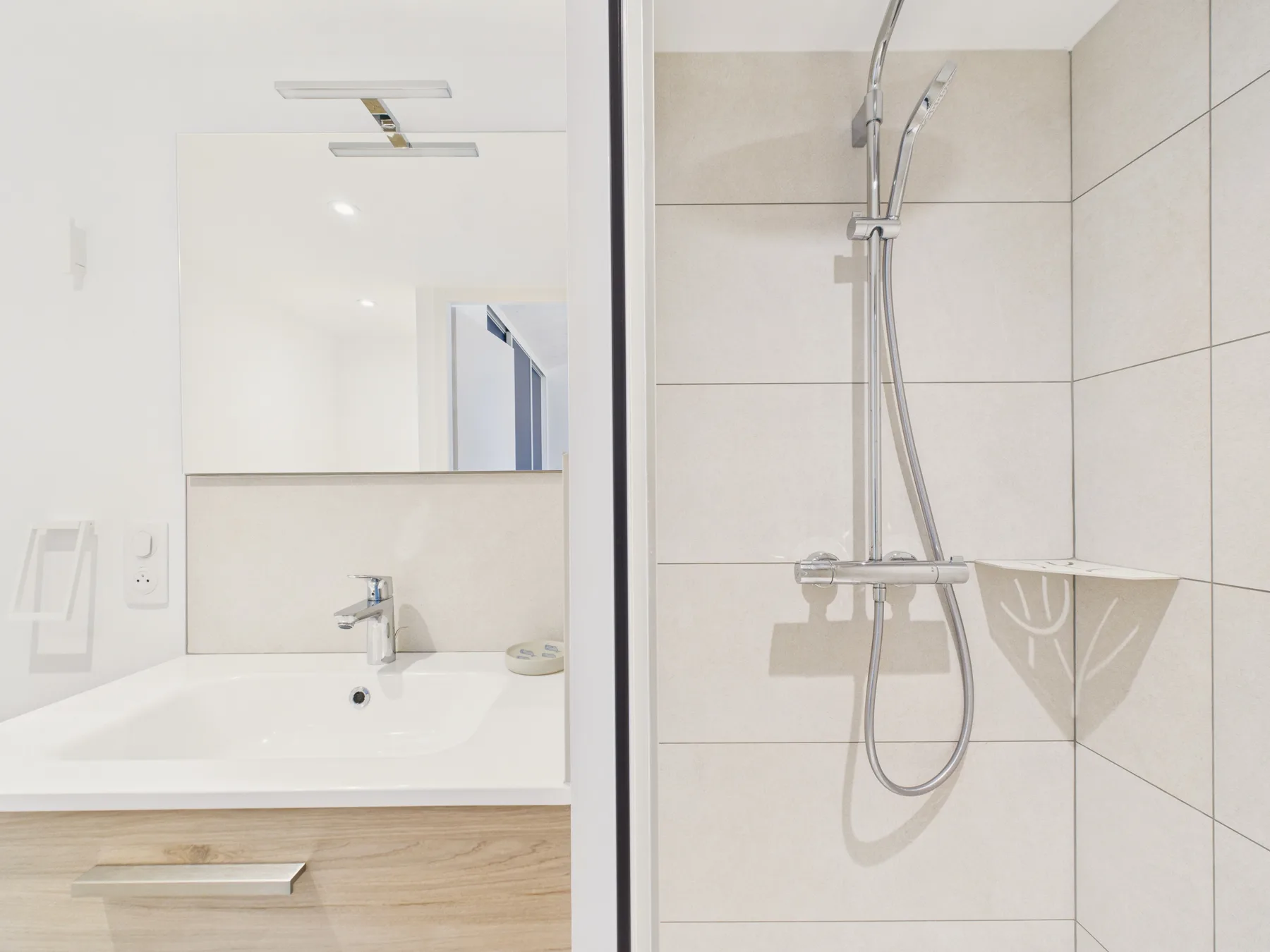 A bright bathroom with a sink and shower.