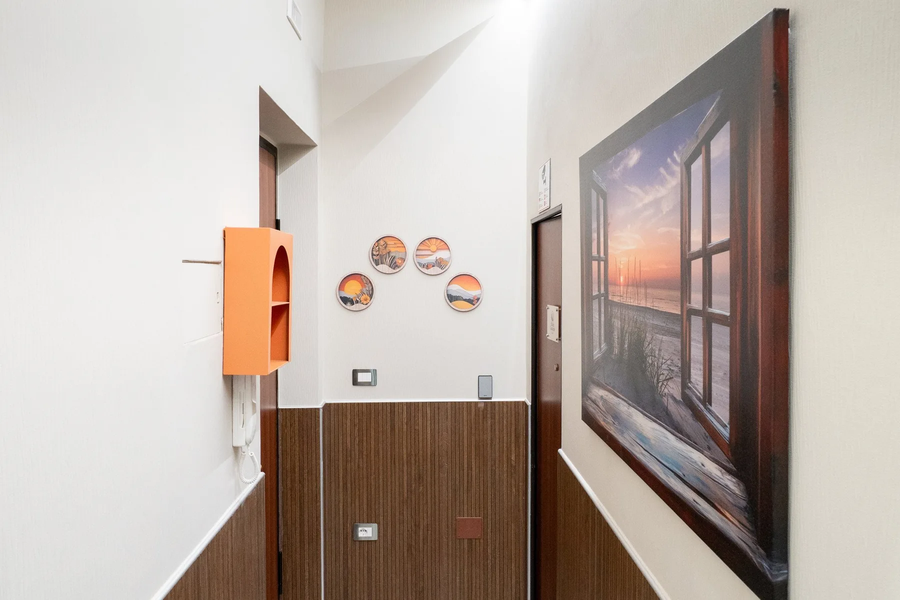 Un pasillo estrecho con paneles de madera, adornos de pared y un cuadro grande enmarcado.