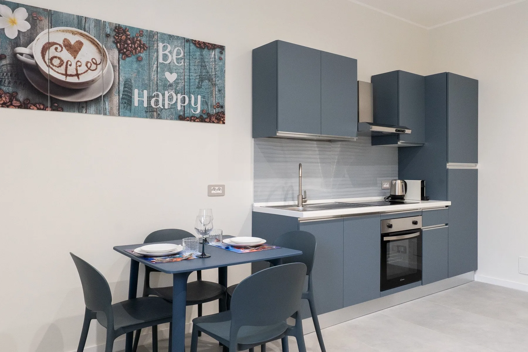 A modern kitchen with dark cabinets and a small dining table.