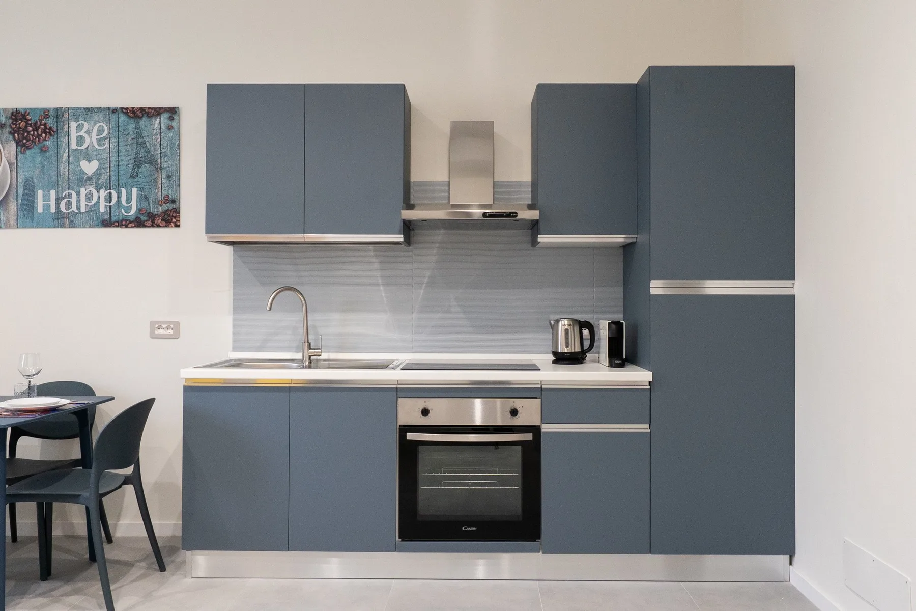 A modern kitchen with blue cabinets, a sink, and an oven.