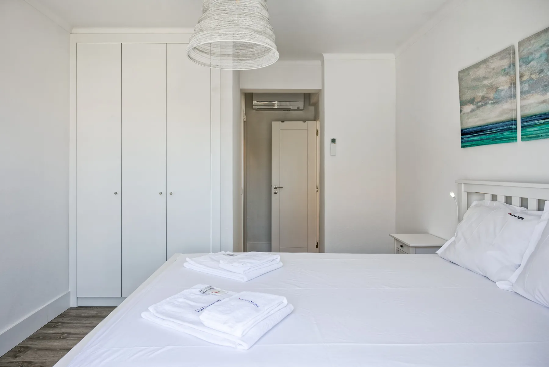 Un dormitorio luminoso con una cama bien hecha y armarios empotrados.