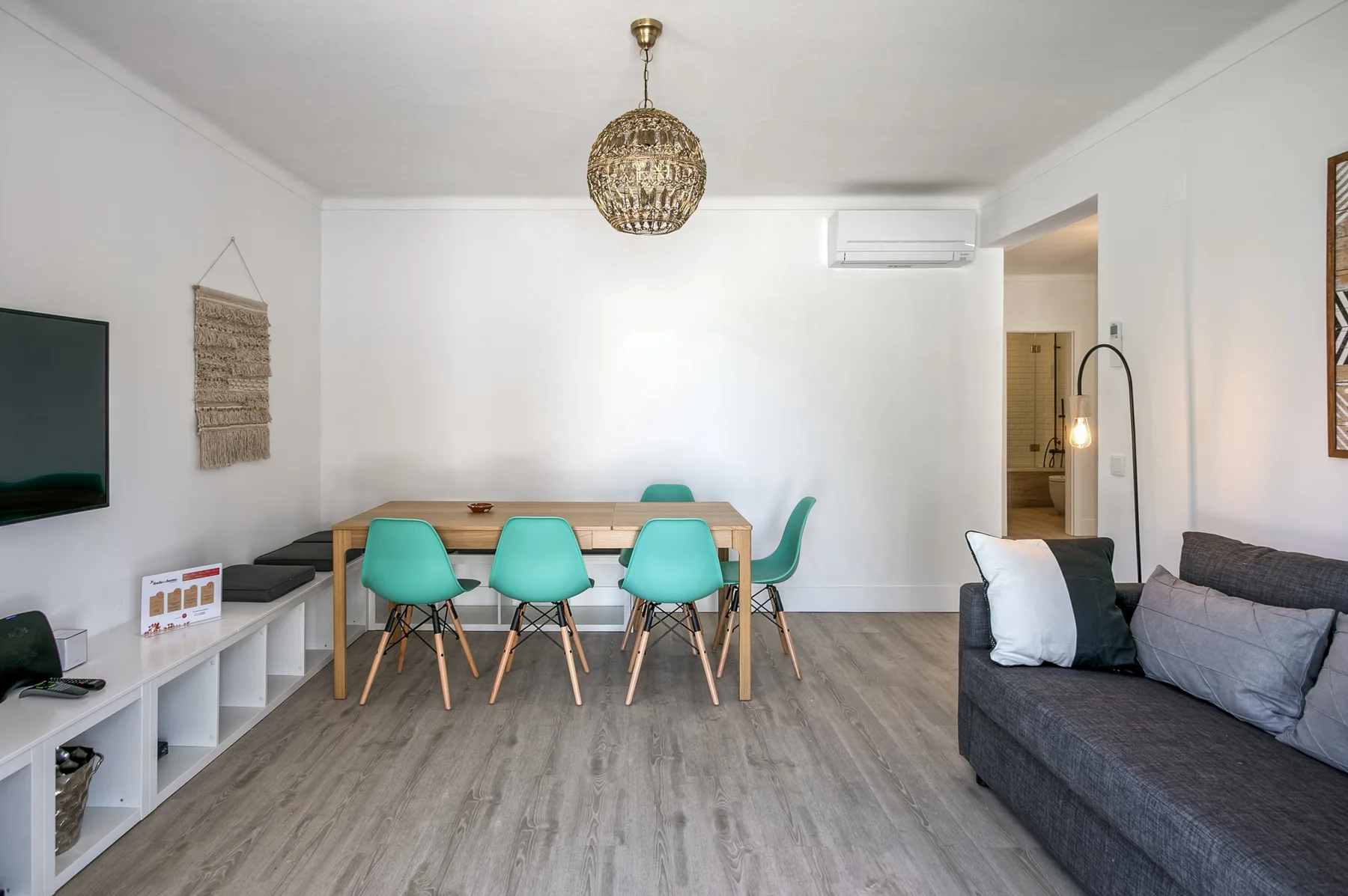 Una luminosa sala de estar y comedor con mesa, asientos y televisor.