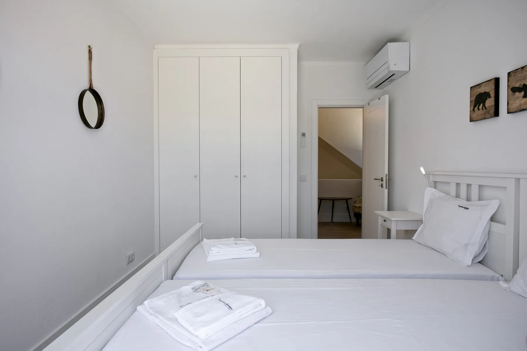 Un dormitorio con una cama bien hecha y un armario.