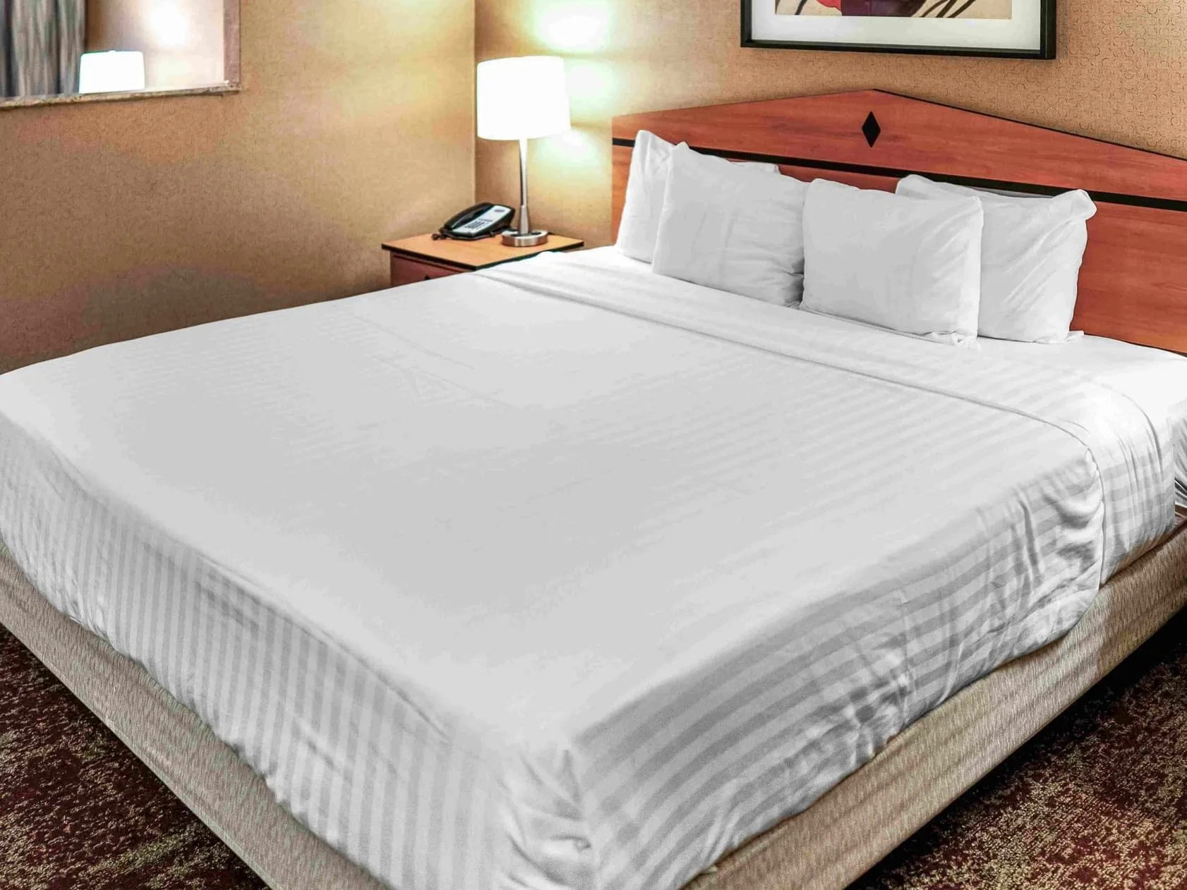 King room with a bed and bedside lamp.