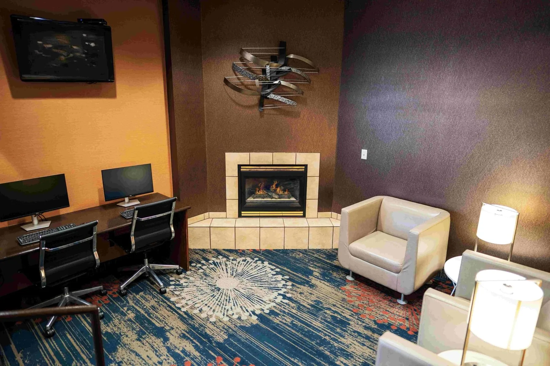 Business center with fireplace, seating, and desks.