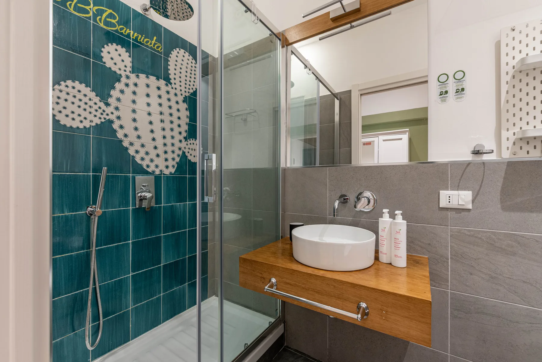 A modern bathroom with a glass shower and a wooden vanity.