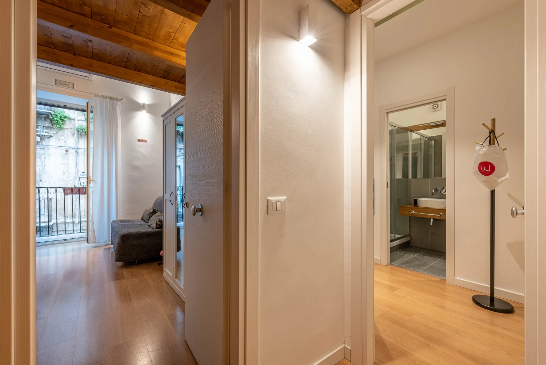 An interior hallway opens onto a living area and a bathroom doorway.