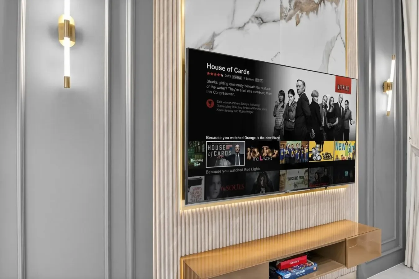 A television displaying a streaming menu is mounted above a wooden console.