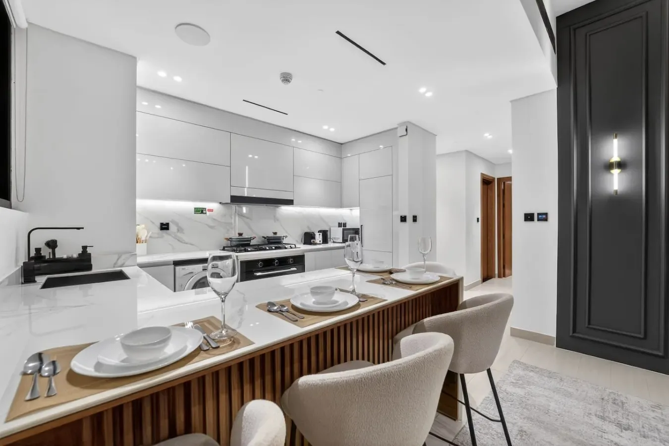 A bright modern kitchen and dining area with a long counter and seating.