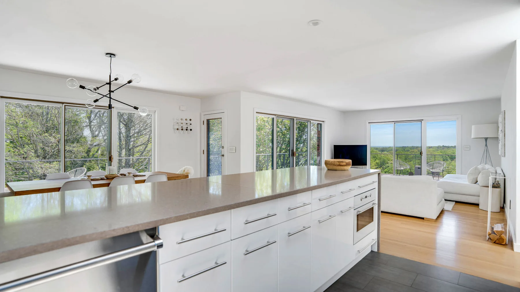 A bright open-plan kitchen and living area with large windows and a central island.