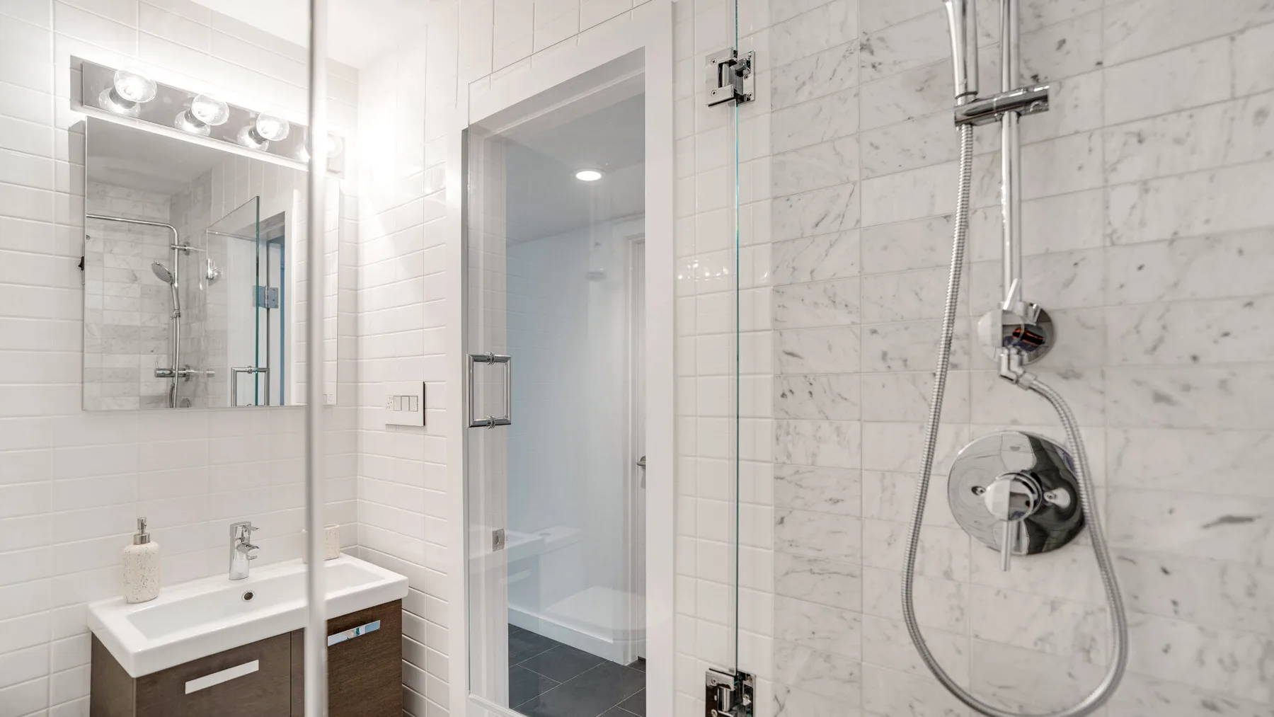 A bright bathroom with a glass shower and a sink.