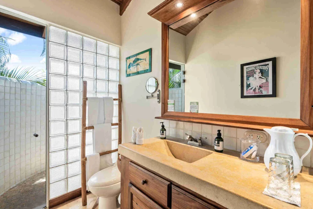 Baño de la habitación con cama queen junto a la piscina