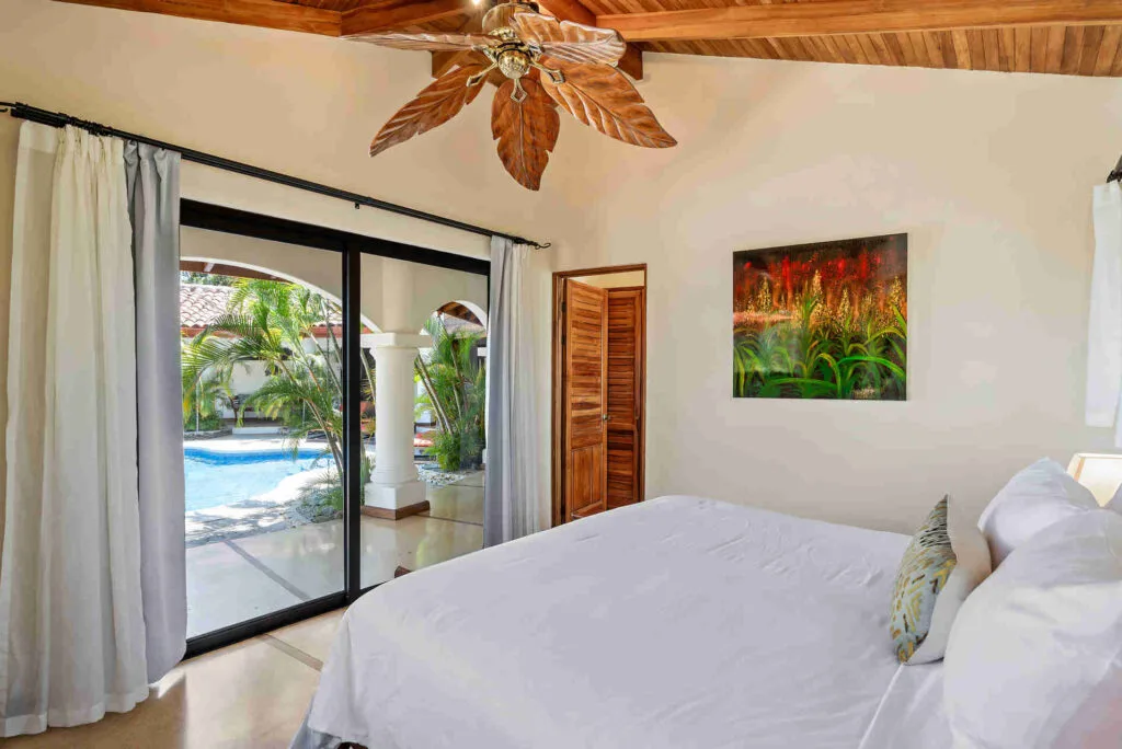 Habitación con cama king junto a la piscina