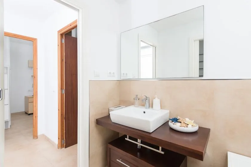 Un mueble de baño con lavabo, encimera y un espejo grande en la pared.
