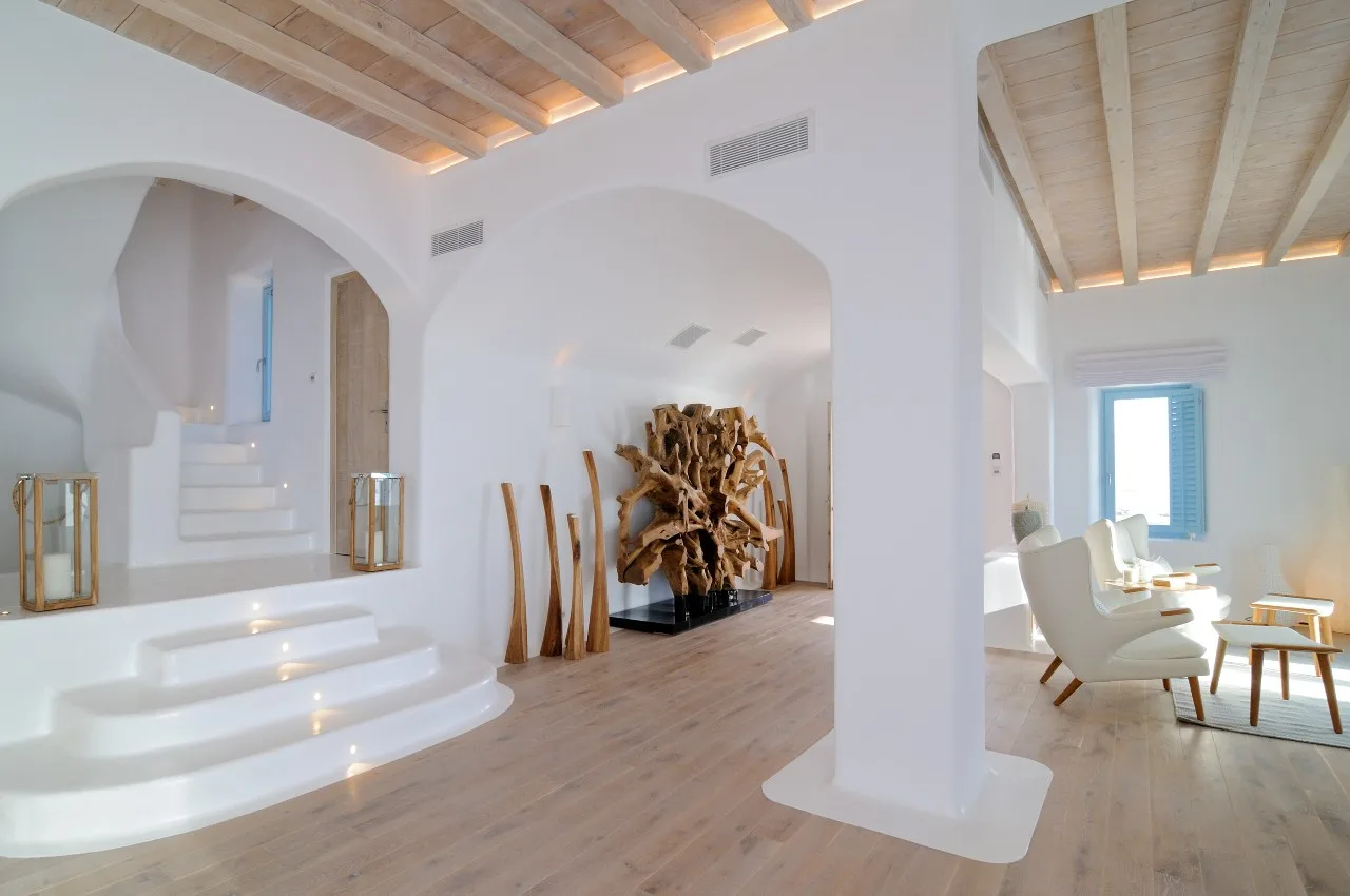 A bright interior with sculptural white stairways and a seating area.