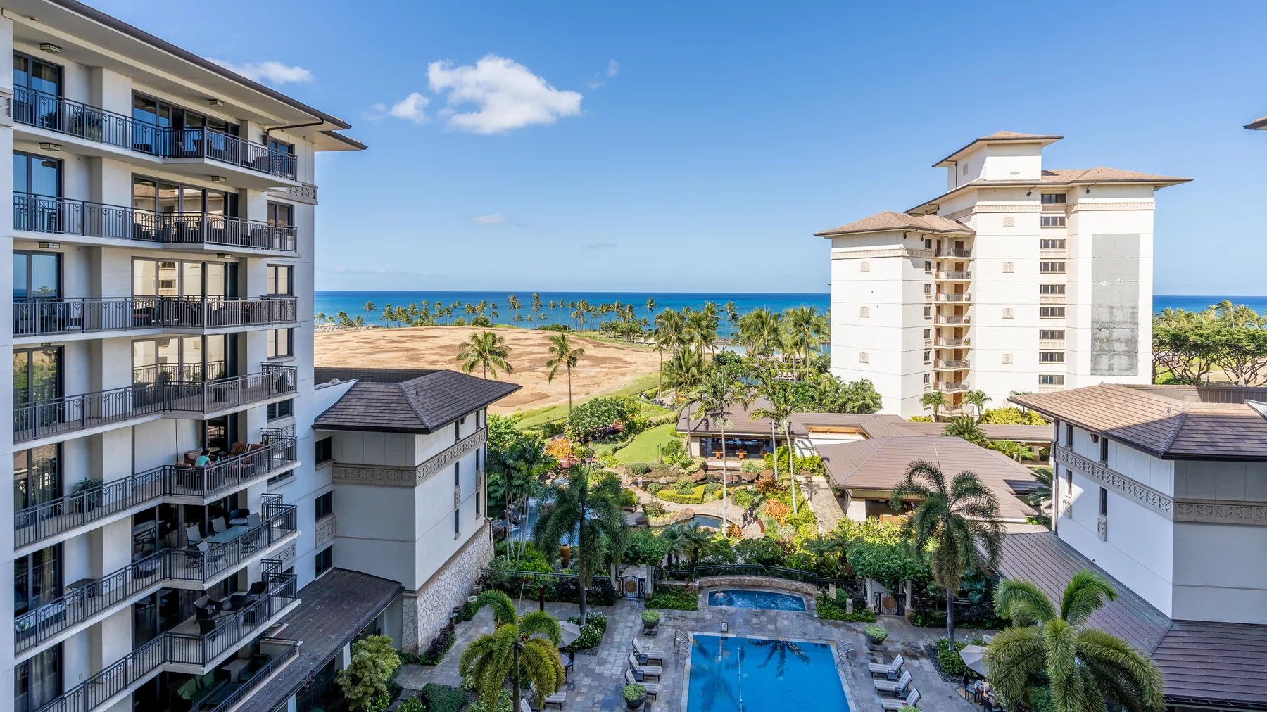 A resort complex overlooks the ocean, with landscaped grounds and a swimming pool.