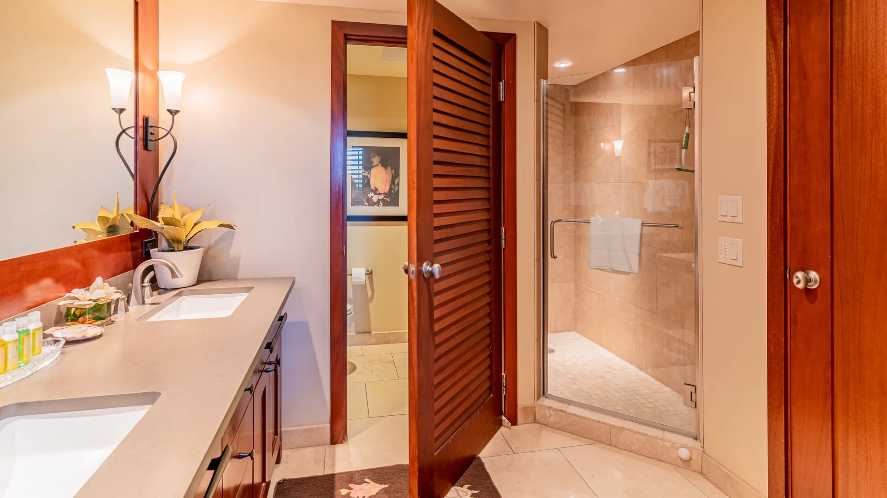 A bathroom vanity and sink sit beside a glass shower.