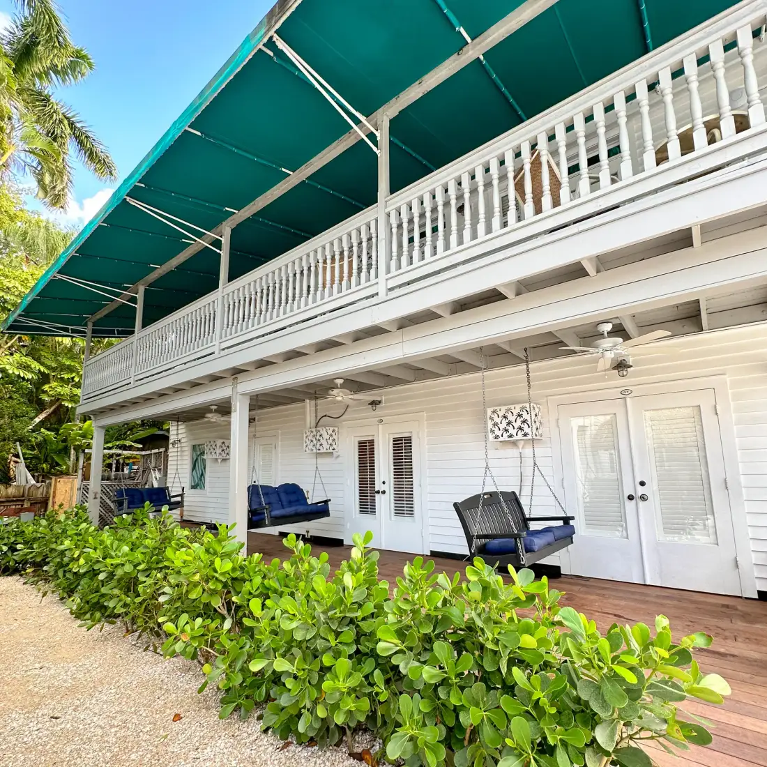 Hotel exterior with outdoor seating and palm trees