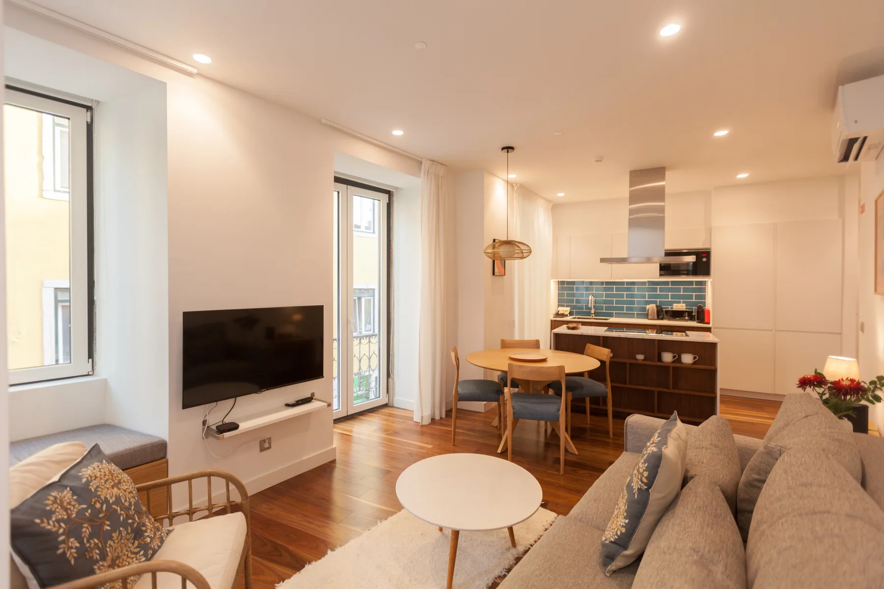 Living room with seating, a television, and an adjoining kitchen and dining area.