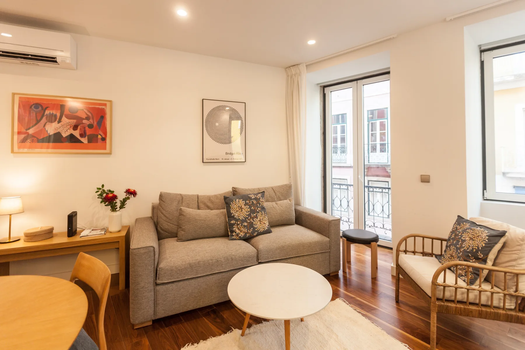 Living room with seating, a coffee table, and windows opening onto a balcony.