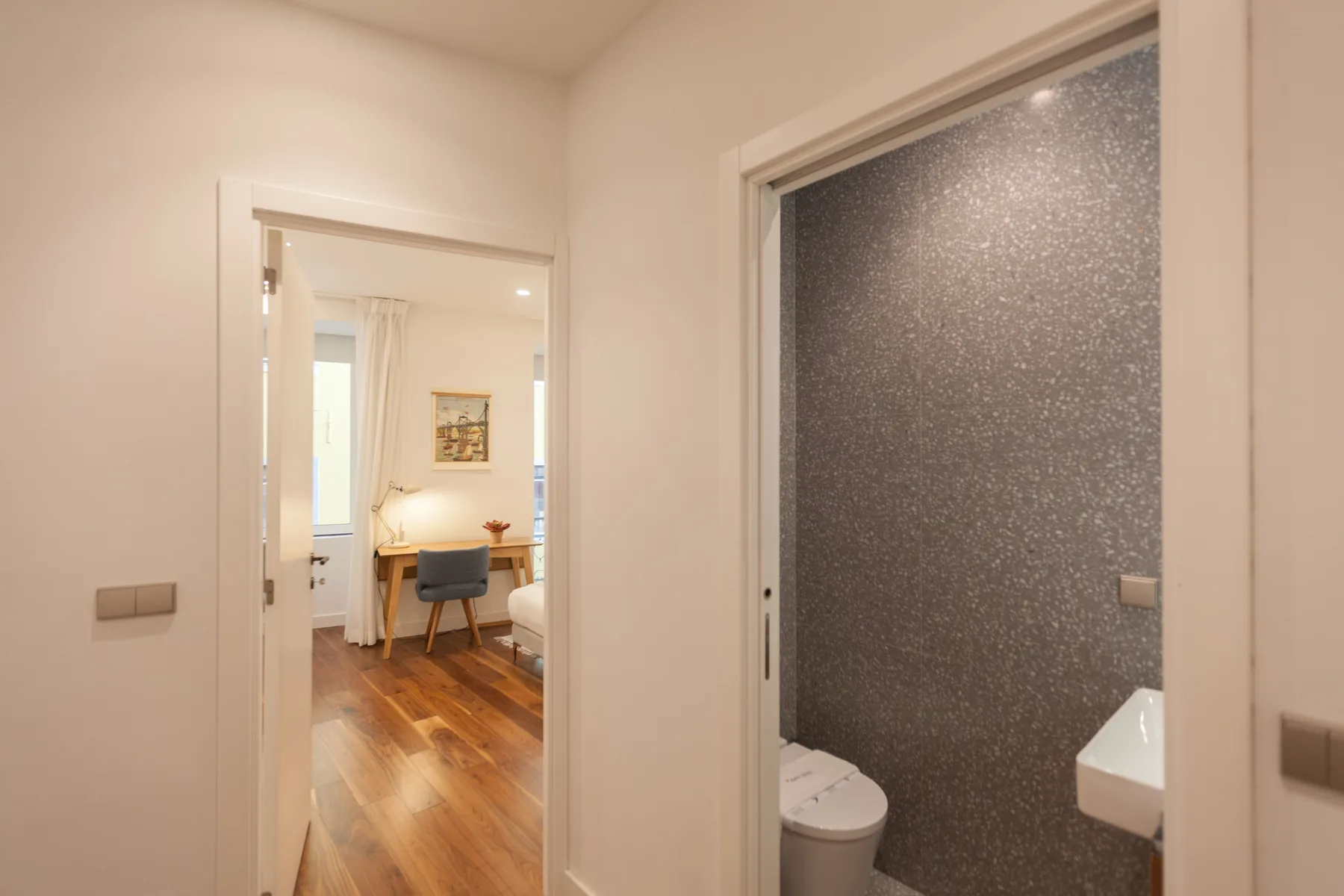 A hallway opens toward a dining area and a bathroom.