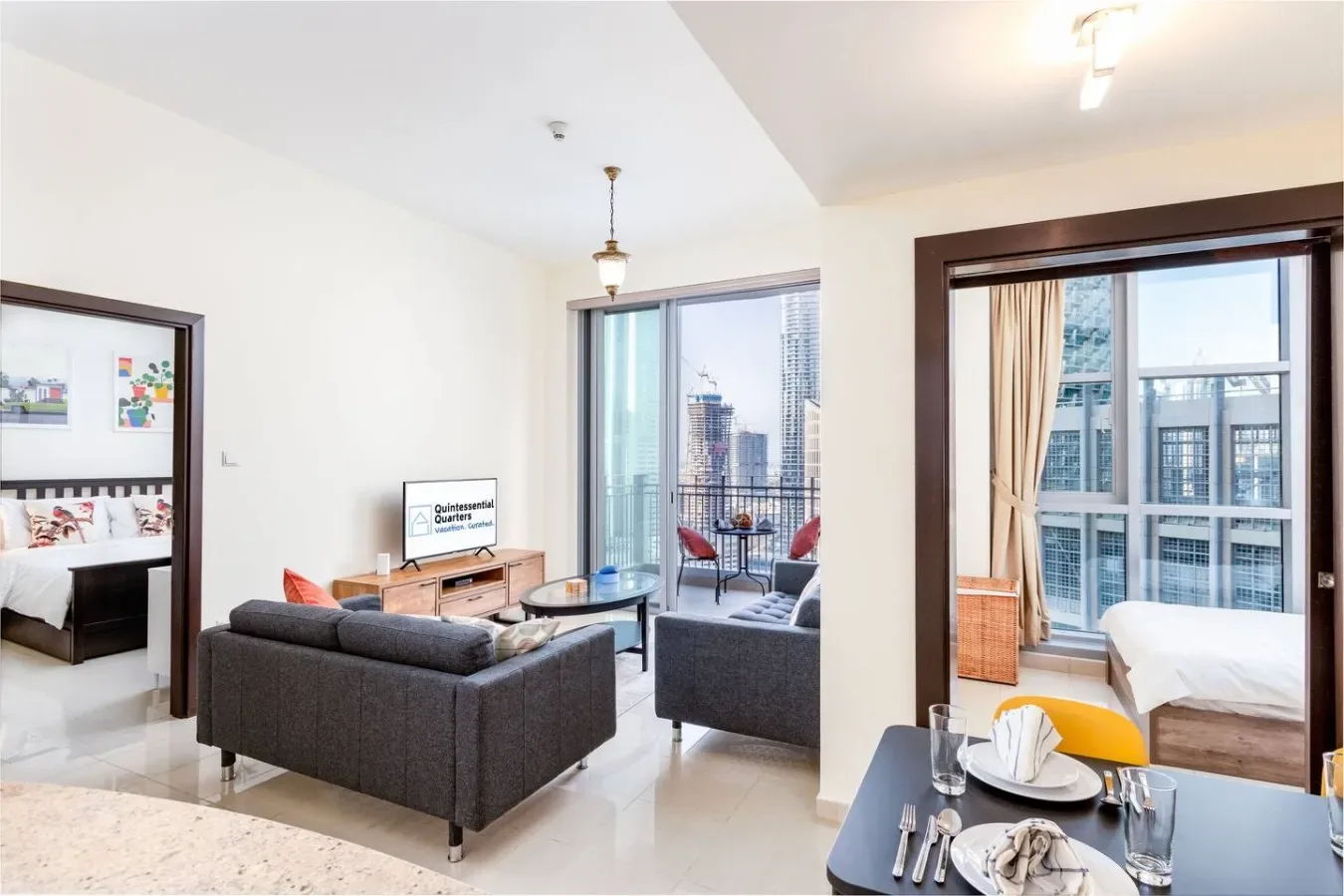 A bright living area opens onto a balcony, with a bedroom visible beside it.