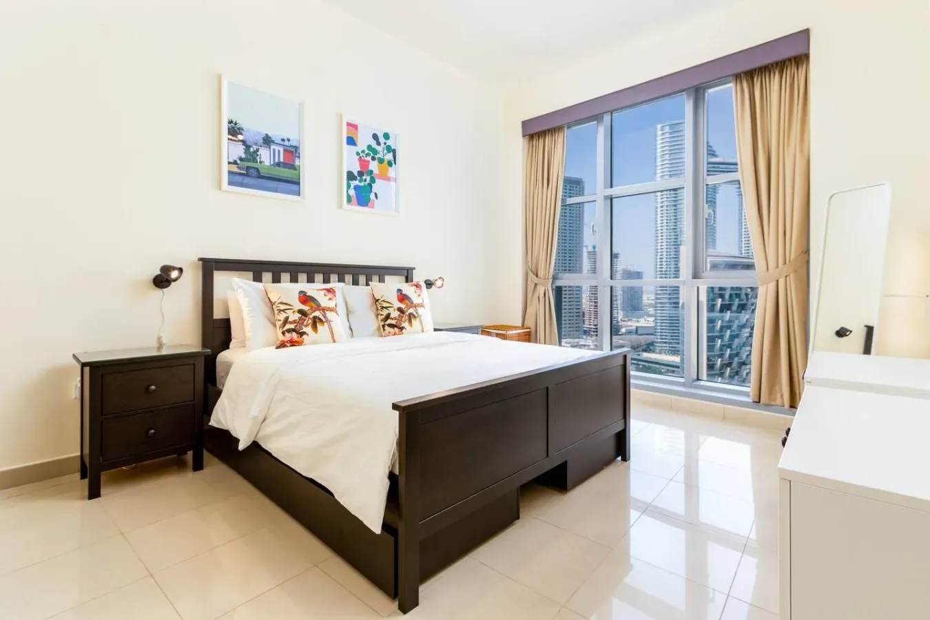 A bright bedroom with a dark wooden bed beside a large window.